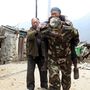Egy sérült nőt cipel egy kínai katona Tibetben. Ez a kép vasárnap reggel 7-kor jelent meg.