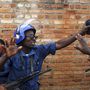 Rendőrtársa próbálja megvédeni a burundi rendőrnőt a feldühödött tömegtől. Azért támadtak rá, mert állítólag lelőtte egy társukat.