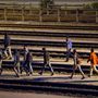 Menekültek sétálnak a sínek között a Csalagútnál