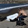Egy helyi lakos holttestet húz a partra Leszbosznál
