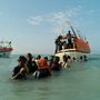 A vállig érő vízben szomáliai menekültek aggódva pásztázzák a partot, hátrahagyott rokonokat, barátokat keresve, mielőtt csuromvizesen felszállnának a Jemen felé induló hajókra.
