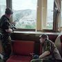 Boszniai lövészek egy szarajevói toronyház kilőtt ablaka mögött.