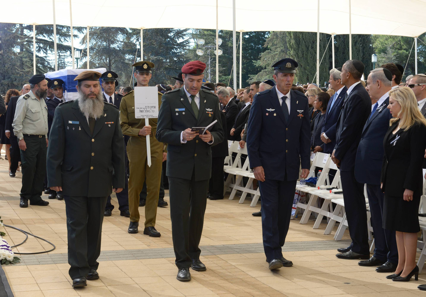 Az Izraeli Védelmi Minisztérium katonái szórnak homokot Peresz sírhelyére