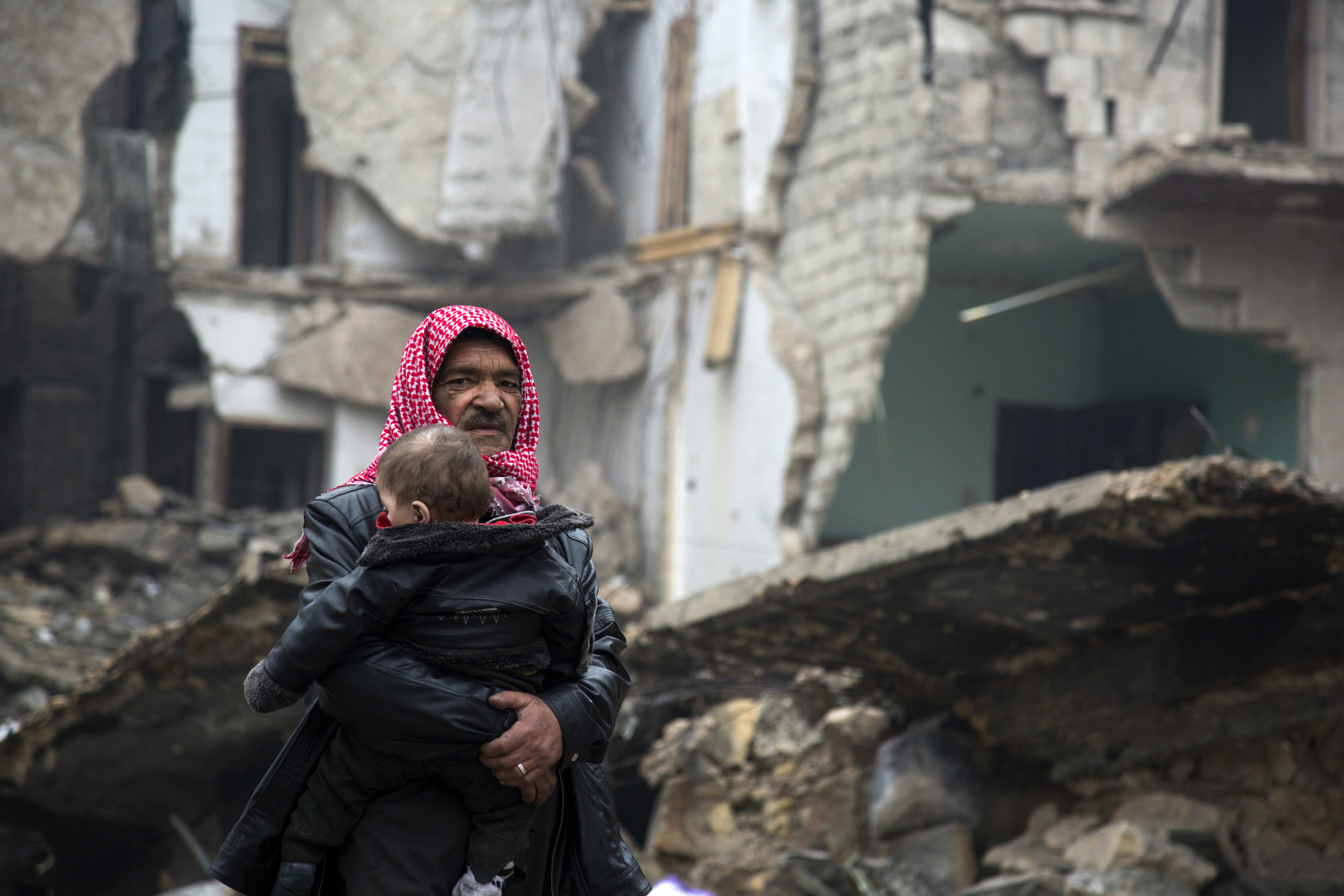 Egyedül sétál a menekülő civilek között egy kisfiú Aleppóban.