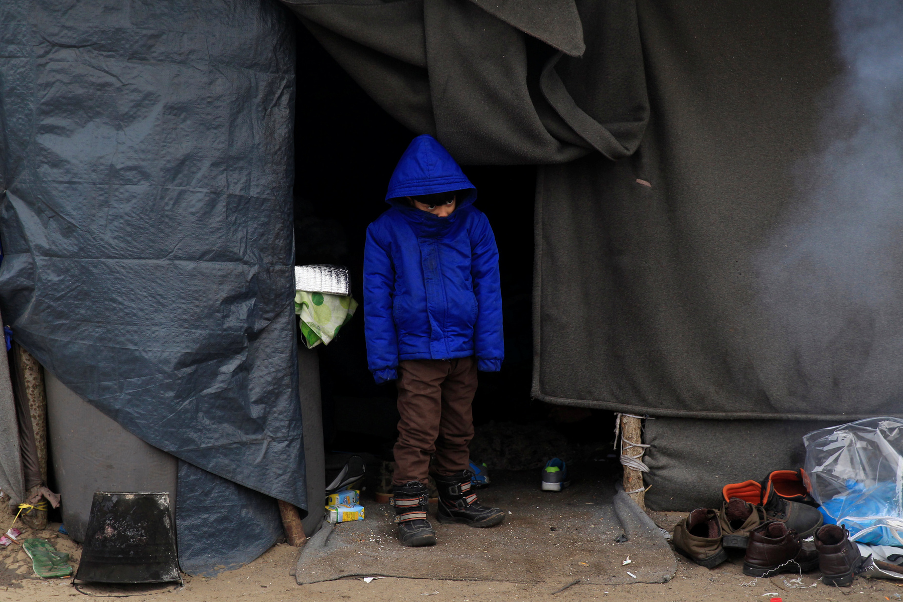 Menekült kisfiú a sátruk előtt Horgosnál. A magyar helyzetet az teszi különösen sokkolóvá, hogy a menekülteket nem kényszerből szállásolták el a hideg sátrakban. Körmenden például a helyszínen járva derítettük ki, hogy a bicskei menekülttábor fűthető szobáiból szállították ide az embereket, miután az amúgy viszonylag elfogadható körülményeket biztosító létesítményt bezárták.  