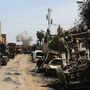 Kiéget utca, a távolban pedig harcok nyomán felszálló füst Moszul nyugati részén