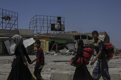 Halott fegyveresek holttestei hevernek a földön egy kivezető út mellett Moszul nyugati részén.