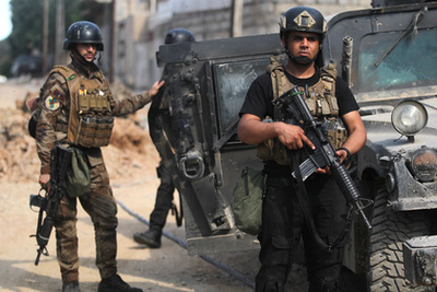 Halott fegyveresek holttestei hevernek a földön egy kivezető út mellett Moszul nyugati részén.