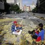 Zenészek játszanak egy metrójegyek borította úttesten a Nicolás Maduro venezuelai elnök alkotmánymódosítási törekvéseit ellenző 24 órás általános sztrájk idején Caracasban.