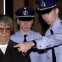 Belga rendőrök bevezetik a brüsszeli igazságügyi palota tárgyalótermébe a sorozatgyilkossággal vádolt  Pándy Andrást 2002. február 18-án. 