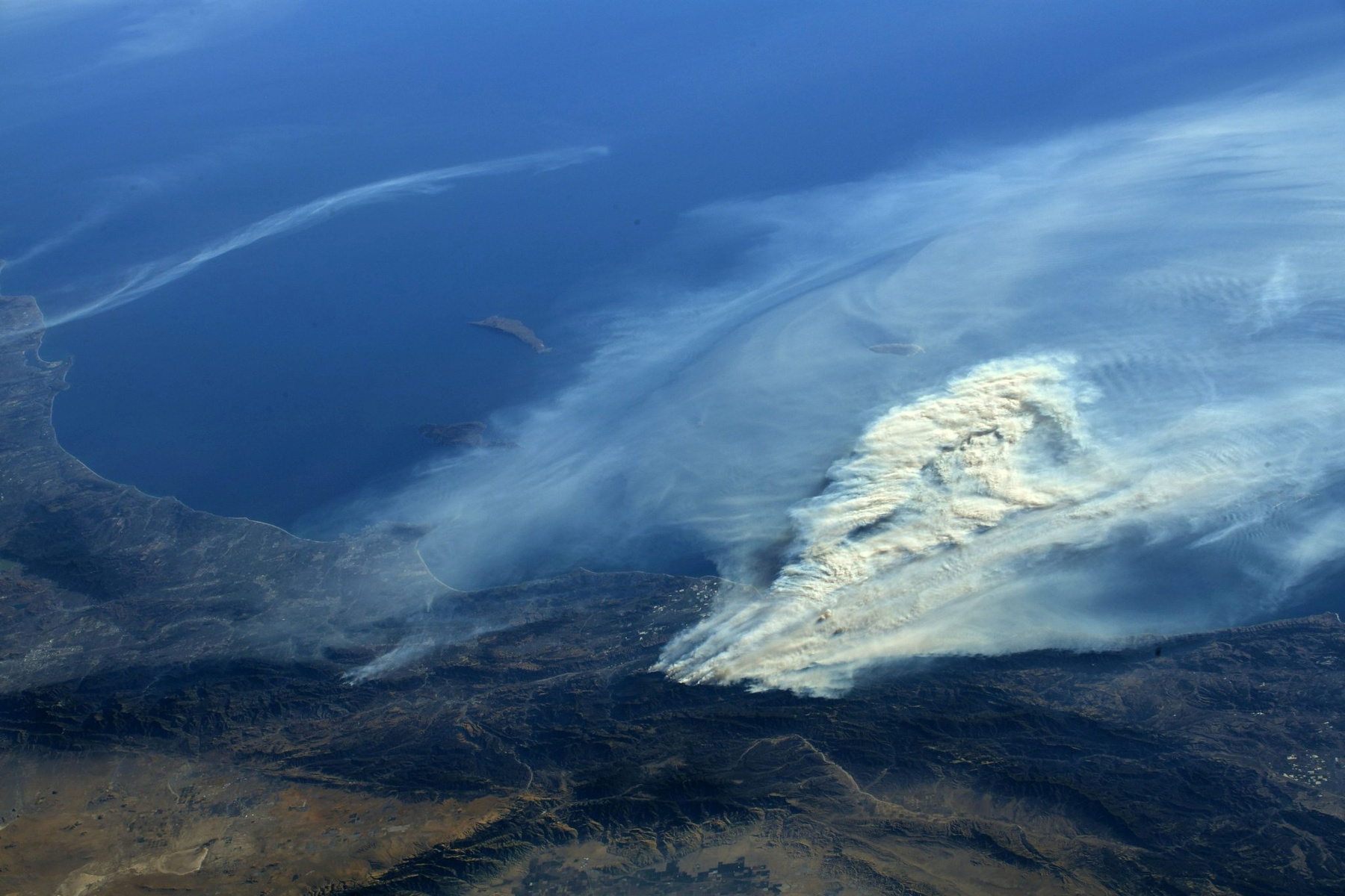 A NASA által kiadott felvétel, amit a ISS (Nemzetközi Űrállomás fedélzetéről készítettek és a Kaliforniában tomboló erdőtüzek füstjéről 2017. december 6-án.