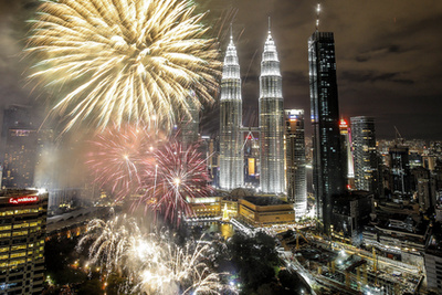 Tűzijáték köszönti az új év beköszöntét a Kuala Lumpur-i 452 méter magas Petronas-ikertornyok mellett szilveszter éjszakáján. 