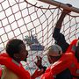 A környéken feltűnt egy angol hadihajó, akik szintén kimentettek egy csónakot az éjjel. A nagyságrendekkel nagyobb és gyorsabb hajó elvállalta, hogy átveszi a Sea-Watch 3 menekültjeit, hogy Szicíliára szállítsa őket. Sierra Leone-i menekültek figyelik a hadihajó közeledését.
Egy szíriai családot leszámítva a legtöbbjüknek nem sok esélye van, hogy menedékjogot kapjon Európába.
