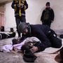 Egy apa siratja a fiát egy halottakat gyűjtő alkalmi ravatalozóhelyen, Dumában.