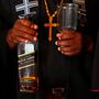 A Gabon egyház egyik papja egy whiskys üveggel a kezében 