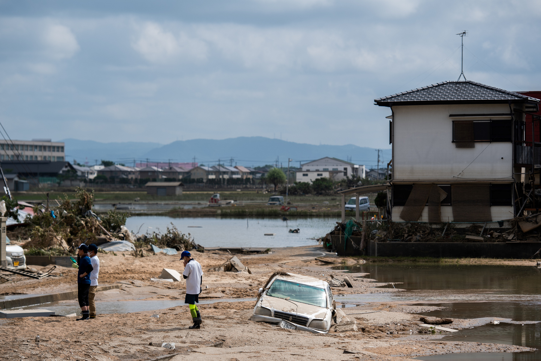 Egy elárasztott házból hordják ki a használhatatlanná vált ingóságokat Okajama prefektúrában