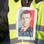 Egy sárga mellényes tüntető Emmanuel Macron képével Párizsban