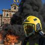Koporsót megjelenítő faládát és egyéb éghető anyagokat égetnek katalán tűzoltók a jobb munkakörülményeket követelő tiltakozóakciójukon a regionális parlament előtt Barcelonában 2018. december 20-án.