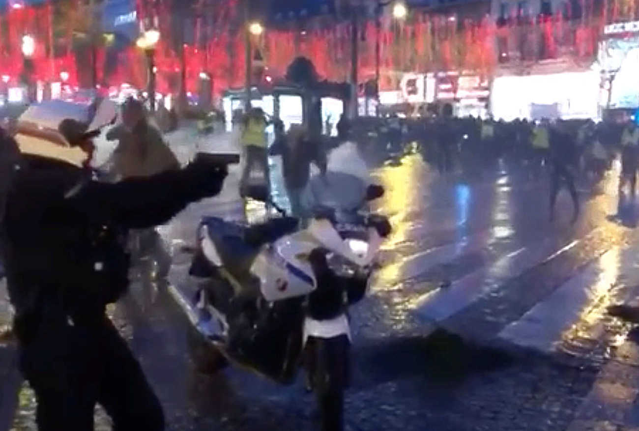A francia sárga mellényes tüntetők könnygáz-tartályokat dobnak vissza a rendőrségnek Párizs központjában, 2018. december 22-én