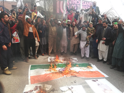 Pakisztáni tüntetők az indiai zászló utánzatát égetik Kasmír pakisztáni fennhatóság alatt álló tartományának fővárosában, Muzáffárábádban 2019. február 28-án