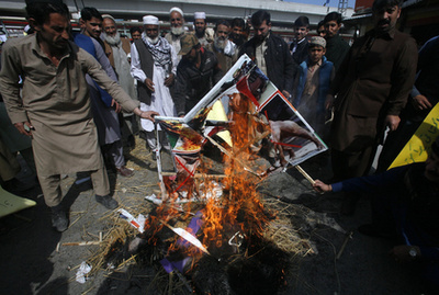 Pakisztáni tüntetők az indiai zászló utánzatát égetik Kasmír pakisztáni fennhatóság alatt álló tartományának fővárosában, Muzáffárábádban 2019. február 28-án