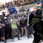A rohamrendőrök paprikasprayvel fújják le az esernyőkkel felfegyverkezett tüntetőket. 