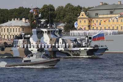 Vlagyimir Putyin orosz elnök (k), Szergej Sojgu védelmi miniszter (b) és Nyikolaj Jevmenov az orosz haditengerészet főparancsnoka a díszszemlén 