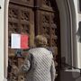 Németország: egy idősebb hölgy olvassa a St. Laurentius templom ajtajára kiragasztott szöveget, miszerint a koronavírus miatt nem lehet nyilvános templomi eseményeket tartani.