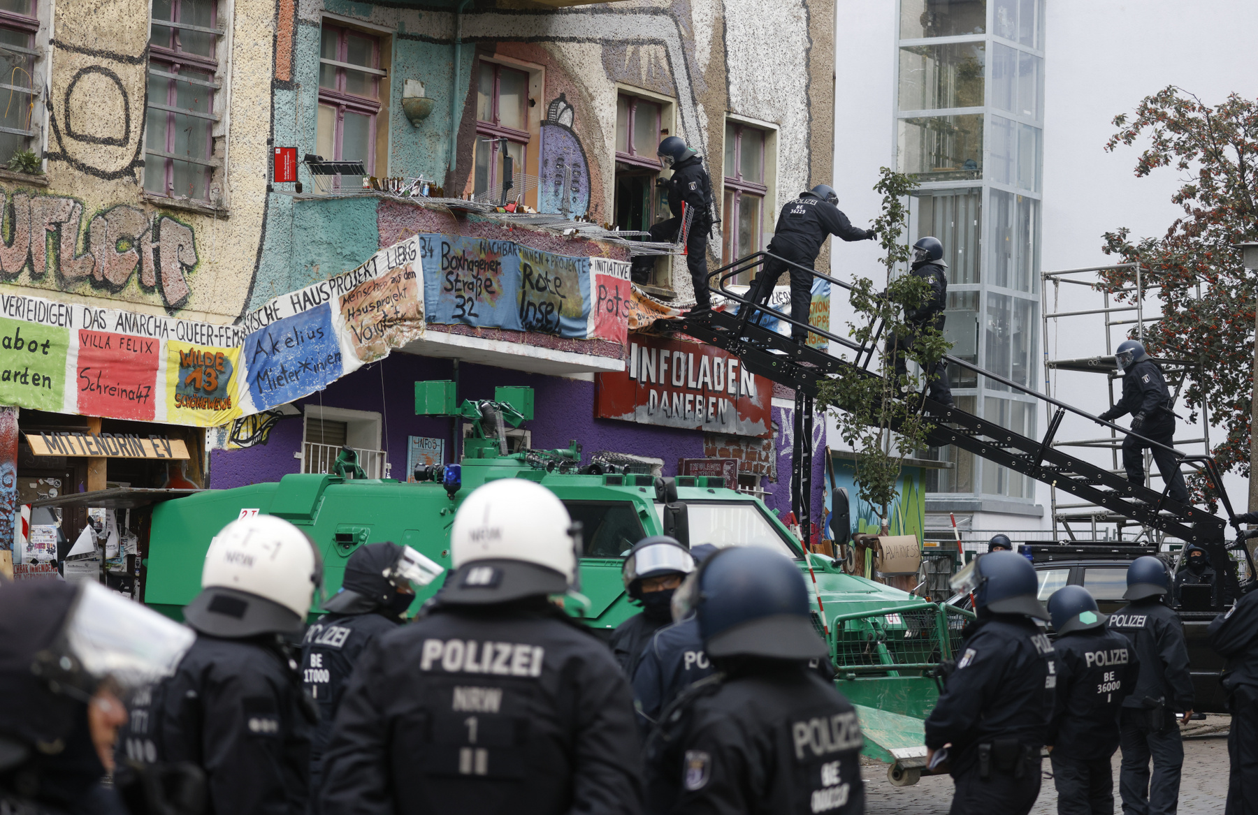 A rendőrség által kitessékelt tüntető emeli fel öklét a berlini Liebig utca 34-nél