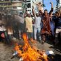 Muszlim tüntetők egy Emmanuel Macron francia elnököt ábrázoló képet égetnek el, amikor részt vesznek a francia termékek bojkottjára szólító tiltakozáson, 2020. október 30-án Banglades fővárosában, Dakkában