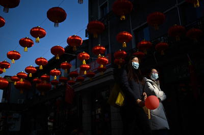 Szelfi után. A közép-kínai Vuhan városában ellenőrzi egy ünneplő fotóját 2021. február 11-én. Innen indult el a koronavírus 2019. decemberében, a következő év márciusában az Egészségügyi Világszervezet, a WHO hivatalosan is világjárványnak minősítette a fertőzést.