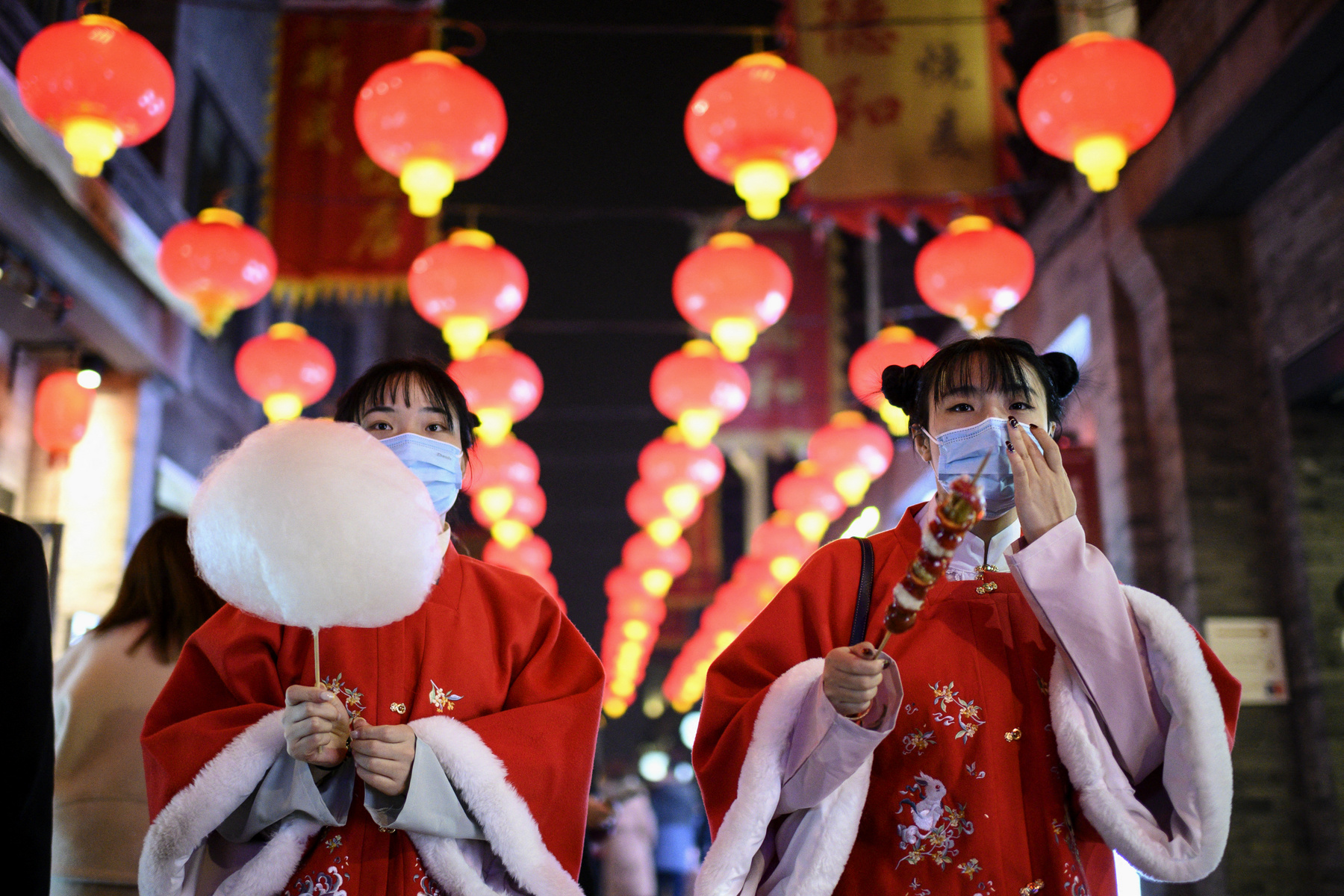 Szelfi után. A közép-kínai Vuhan városában ellenőrzi egy ünneplő fotóját 2021. február 11-én. Innen indult el a koronavírus 2019. decemberében, a következő év márciusában az Egészségügyi Világszervezet, a WHO hivatalosan is világjárványnak minősítette a fertőzést.