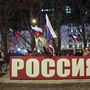 Orosz zászlókkal ünnepelnek emberek Donyeck belvárosában hatalmas Oroszország felirattal 2022. február 21-én