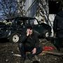 Egy férfi ül Csuhuiv városában egy lerombolt épület előtt 2022. február 24-én