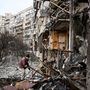 Egy férfi takarítja a törmelékeket egy megsérült lakóépületnél Kijev külvárosában 2022. február 25-én