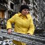 Egy nő takarítja a törmelékeket egy megsérült lakóépületnél, Kijev külvárosában 2022. február 25-én