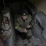 Az ukrán területvédelmi alakulatok egyik tagja vadászfegyverrel a kezében jön ki egy ház pincéjéből, amely zsúfolásig megtelt az orosz légicsapások és ágyúzások elől menekülő emberekkel, a Kijev közelében lévő Horenka településen 2022. március 2-án