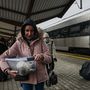 Egy nő egy házinyulat tart a kezében a lengyel Przemyśl főpályaudvarán 2022. február 23-án
