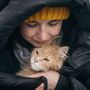 Egy Ukrajnából menekült nő határátlépés után a romániai Szeretvásáron védi macskáját a hidegtől 2022. március 2-án