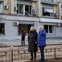 Lakosok egy robbanásban megsérült épület mellett 2022. március 16-án