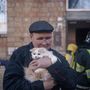 Egy férfi menekül ki macskájával egy megrongálódott lakóházból 2022. március 18-án