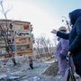 Lakók egy támadásban megsérült épület előtt Kijevben 2022. március 18-án