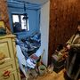 A 70 éves Ljudmila mutatja lakását egy ágyúzásban súlyosan megrongálódott házban Donyeckben 2022. december 6-án
