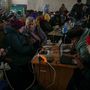 Emberek töltik elektronikus eszközeiket egy vasútállomáson az oroszok kivonulása után Herszonban Ukrajnában 2022. november 29-én