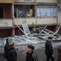 Helyi lakosok takarítják az erkélyt egy orosz rakétatámadás által megrongált lakóépületben a Kijev melletti Vishorod városában 2022. november 24-én