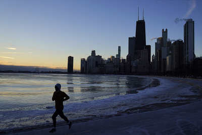 A Michigan-tó jéggel borított partja mellett fut egy kocogó Chicago belvárosában 2023. február 3-án