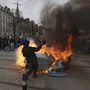 A nyugdíjreform ellen tüntetők egyike egy felgyújtott szemetesedény mellett a nyugat-franciaországi Nantes-ban a francia szakszervezetek által meghirdetett egynapos országos sztrájk alatt, 2023. március 23-án