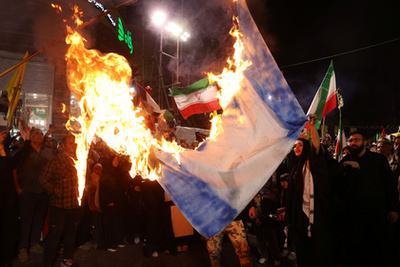 Emberek fényképeket készítenek a Bejrút déli részén levő Dahiyeh környékén végrehajtott izraeli légicsapást követően 2024. október 6-án