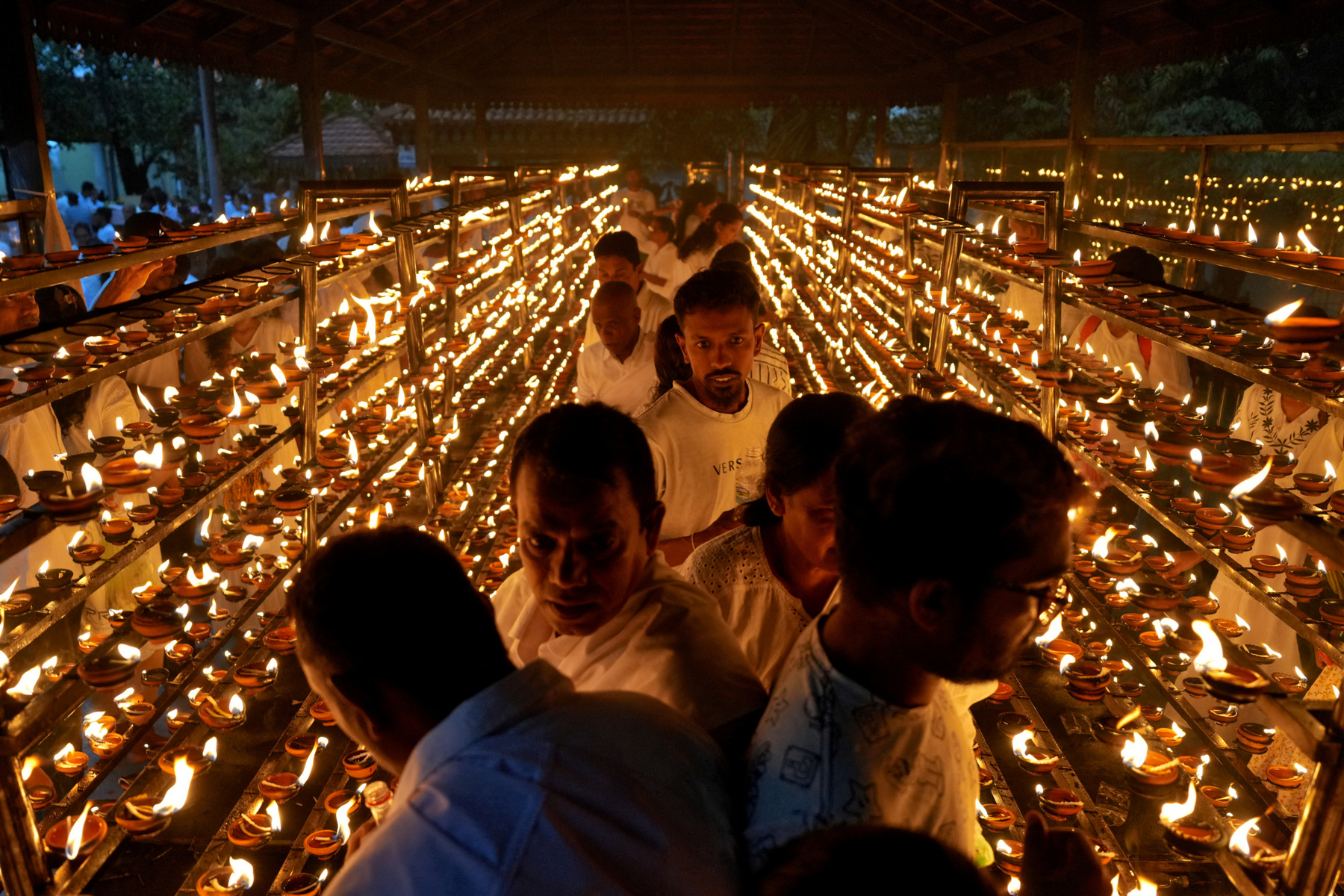 Buddhista hívők követik a kocsik felvonulását a Vesak-napi felvonulások során Malajziában 2025. május 12-én