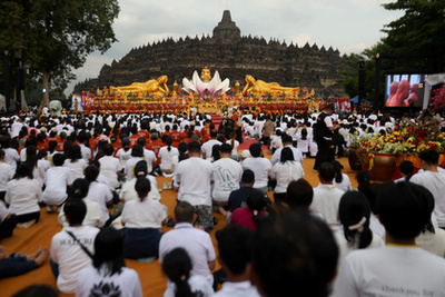 Buddhista hívők követik a kocsik felvonulását a Vesak-napi felvonulások során Malajziában 2025. május 12-én